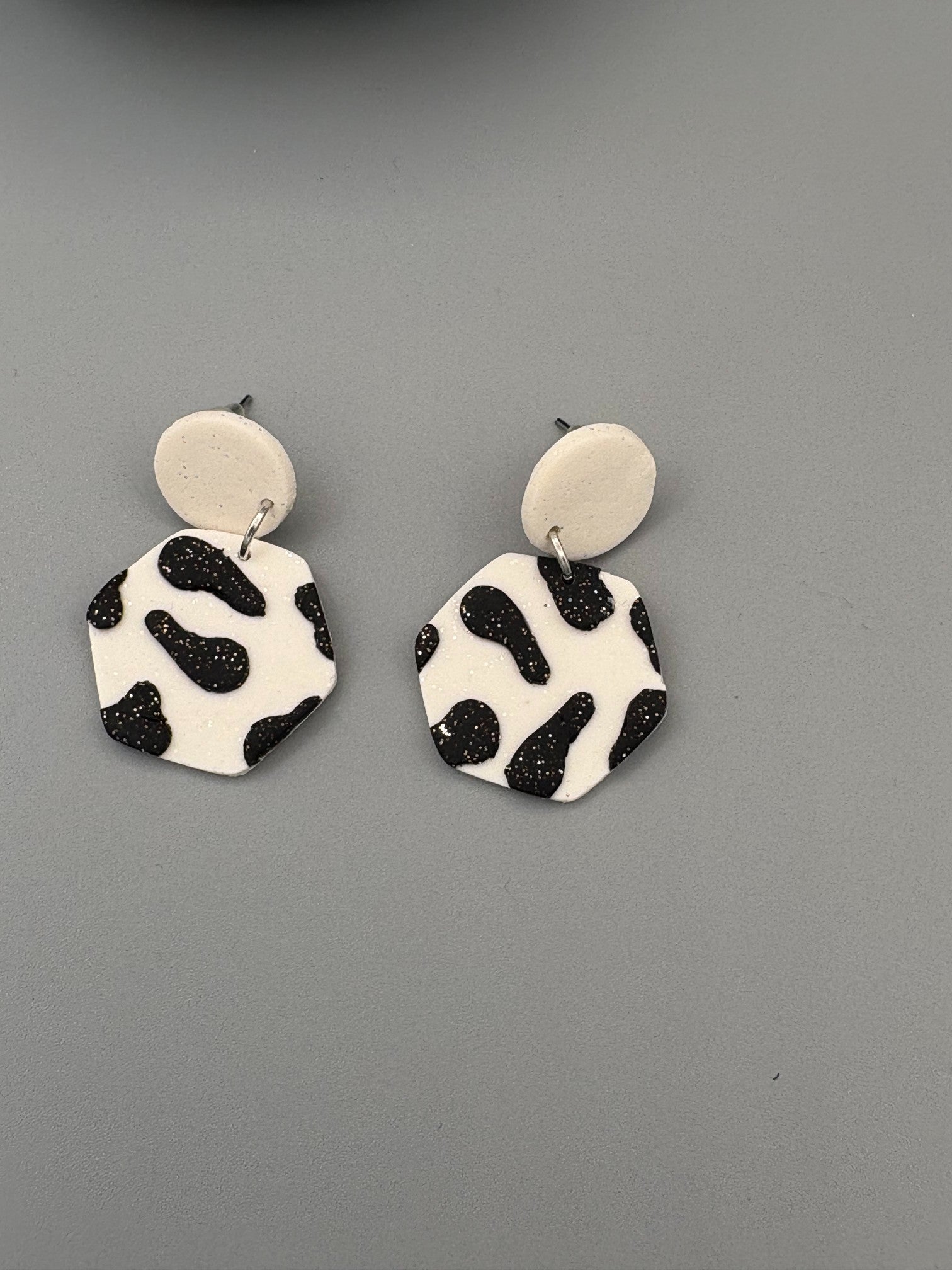 Black Cow Print Hexagon Dangle Earrings - handcrafted polymer clay earrings by Lakeside Clay