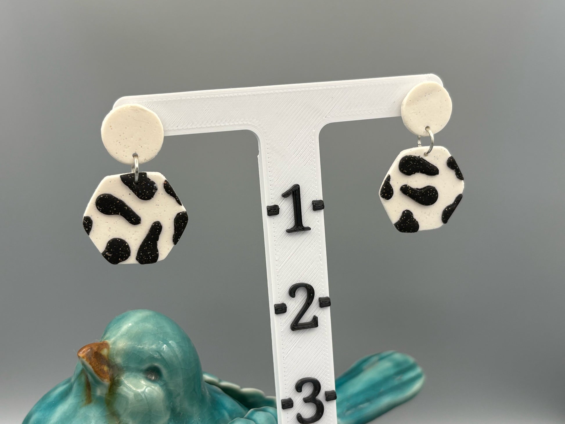 Black Cow Print Hexagon Dangle Earrings - handcrafted polymer clay earrings by Lakeside Clay