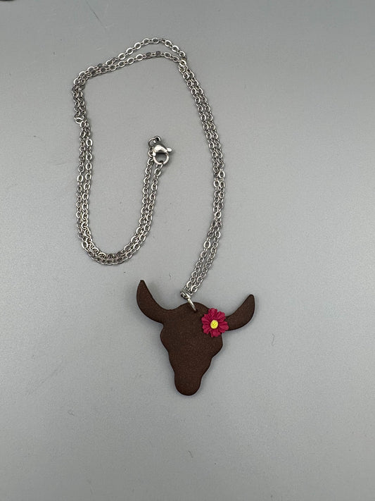 Bœuf avec collier de fleurs magenta